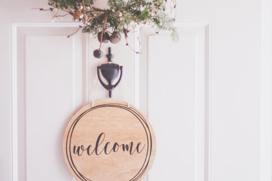 A stylish welcome sign with festive greenery on a door, perfect for home decoration.