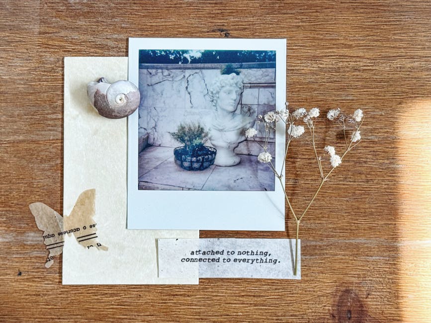 A curated flat lay featuring a Polaroid photo, seashell, butterfly cutout, text, and dried flowers on a wooden surface.