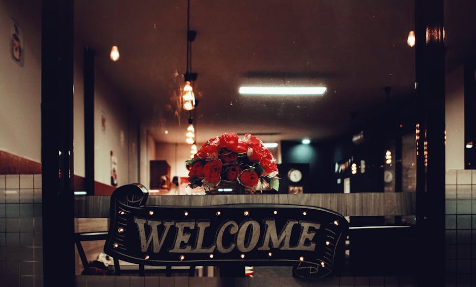 Warm and inviting restaurant interior with a welcoming sign and flower bouquet.