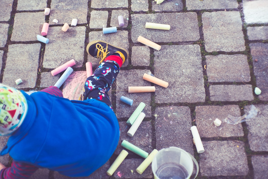 a child is playing with crayons on the ground
